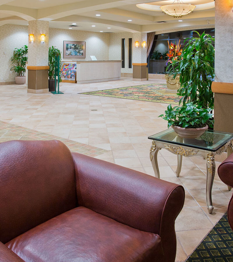 Elegant hotel lobby with leather couches and plants at the Holiday Inn North Vancouver
