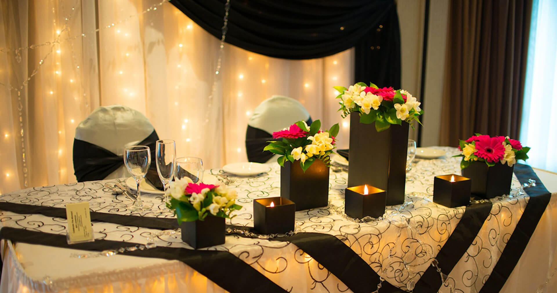 Dining table set in black and white theme with flowers and candles