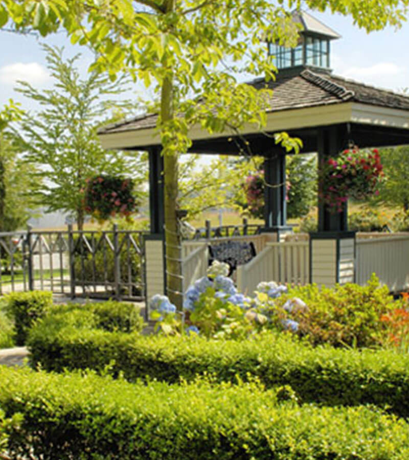 Gazebo amidst trees, flowers and manicured shrubs