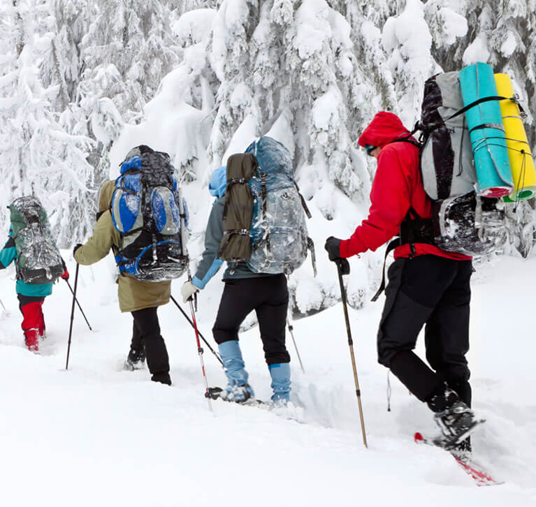 Skiers hiking up a snowy trail