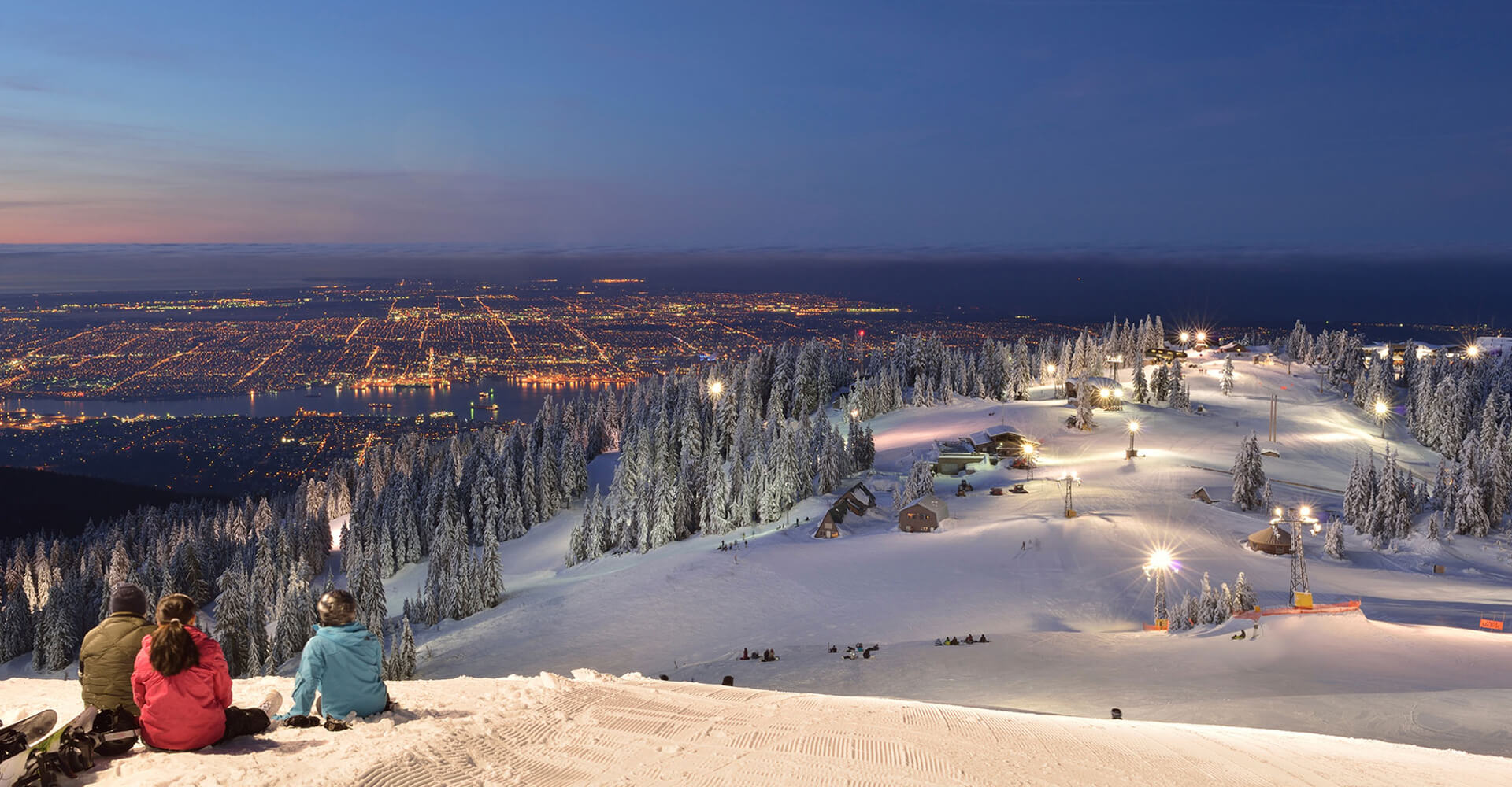 People taking in Vancouver's scenic views atop a snowy mountain